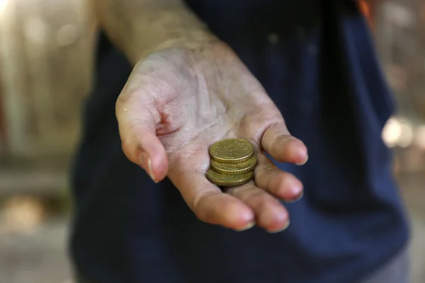 Hemlösa tiggare pengar på sina smutsiga händer — Stockfoto