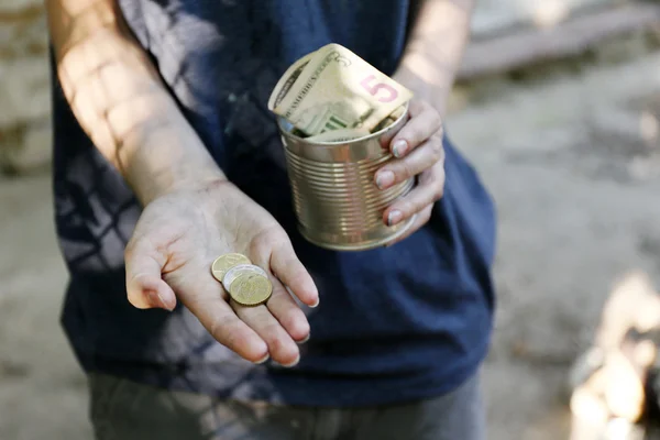 Hemlösa tiggare pengar på sina smutsiga händer — Stockfoto