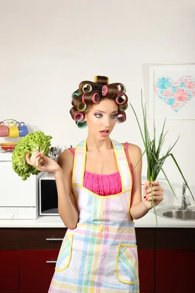 Beautiful girl in hair curlers in kitchen — Stock Photo, Image