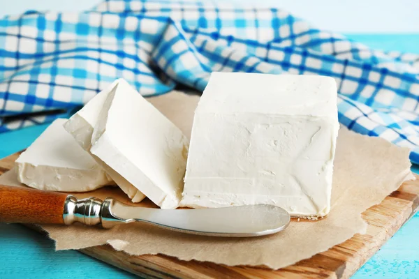 Čerstvé máslo na prkénko, na barevné dřevěné pozadí — Stock fotografie