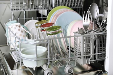 Open dishwasher with clean utensils in it clipart