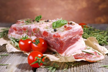 baharatlar ve ahşap masa üstünde domates çiğ domuz pastırması