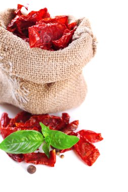 Güneş kurutulmuş domates üzerinde beyaz izole çul çanta ve fesleğen yaprakları