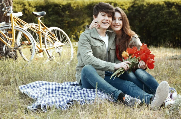 Unga paret sitter i parken med cyklar — Stockfoto