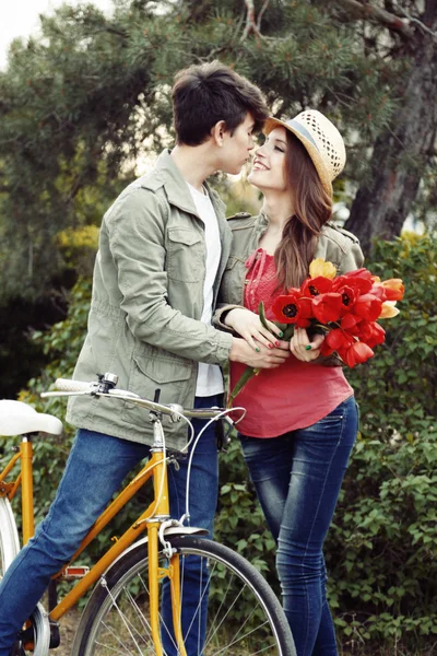 Jeune couple avec vélo dans le parc — Photo