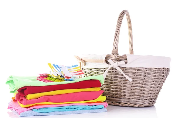 Bright clothes and empty wicker basket, isolated on white — Stockfoto
