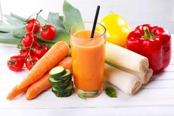 Copo de suco de cenoura fresca e legumes na mesa de madeira — Fotografia de Stock