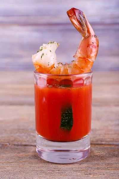 Čerstvé vařené krevety ve sklenici s rajskou omáčkou na dřevěné pozadí — Stock fotografie