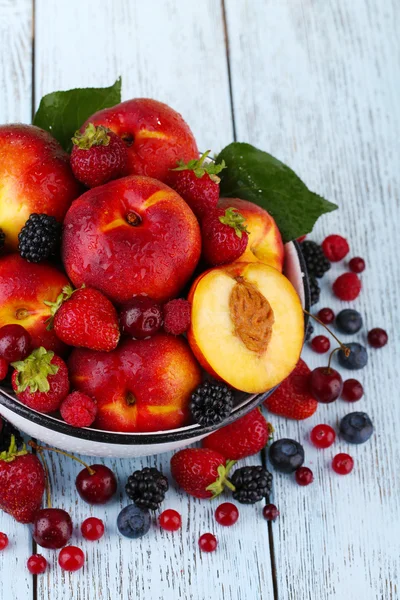 Őszibarack és a bogyós gyümölcsök csészében asztalra — Stock Fotó