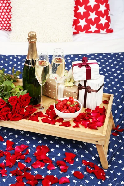 Bodegón romántico con champán, fresa y rosas en la cama —  Fotos de Stock