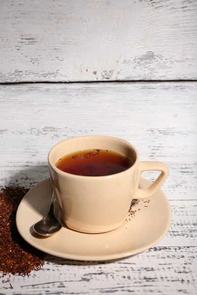 Cup of tasty rooibos tea, on old white wooden table — Stock Photo, Image