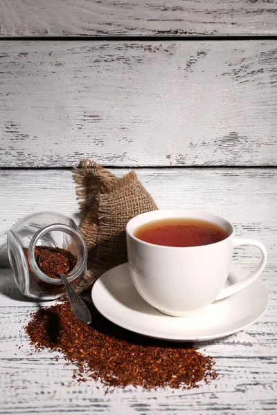 Cup of tasty rooibos tea, on old white wooden table — Stock Photo, Image