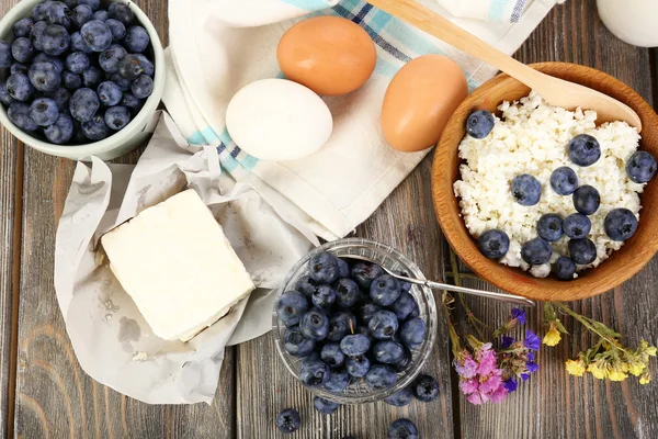 Arándanos frescos y productos lácteos sobre mesa de madera — Foto de Stock