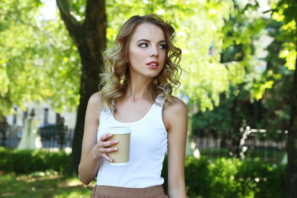 Hermosa joven con café en la calle de la ciudad — Foto de Stock