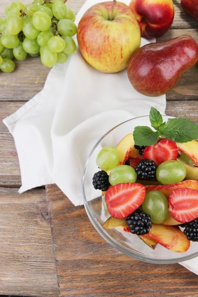 Lekkere en verse fruitsalade op houten tafel — Stockfoto