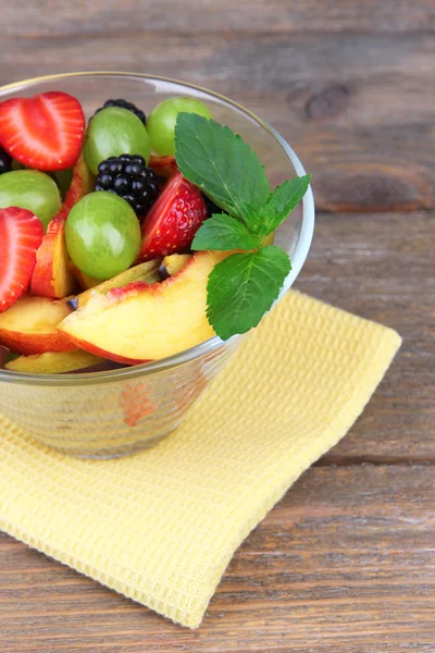 Fresh tasty fruit salad on wooden table — Stock Photo, Image