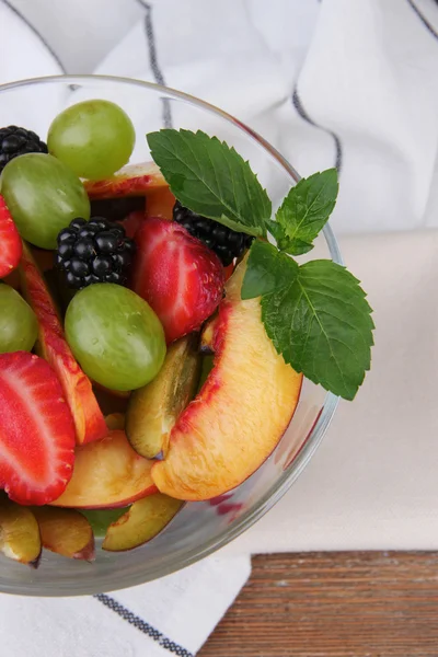 Fresh tasty fruit salad on wooden table — Stock Photo, Image