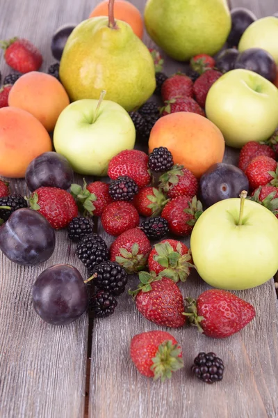 Спелые плоды и ягоды на деревянном фоне — стоковое фото