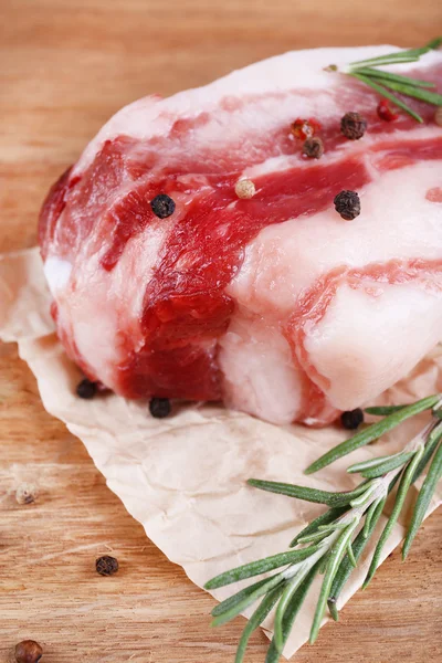 Raw bacon with spices on wooden table — Stock Photo, Image