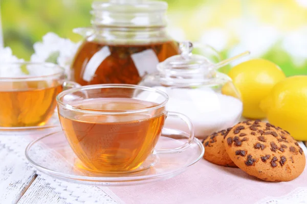 Teapot and cups of tea on table on bright background — Stock Photo, Image