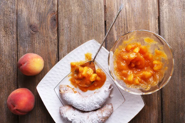 Gustosa marmellata di pesche con pesche fresche e croissant sul tavolo di legno — Foto Stock