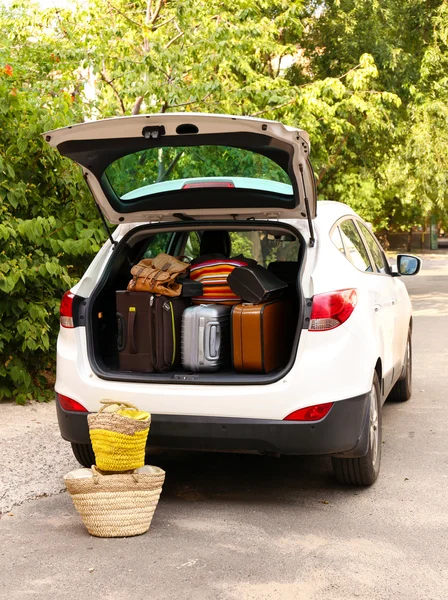 Maletas y bolsas en maletero de coche listas para salir de vacaciones — Foto de Stock