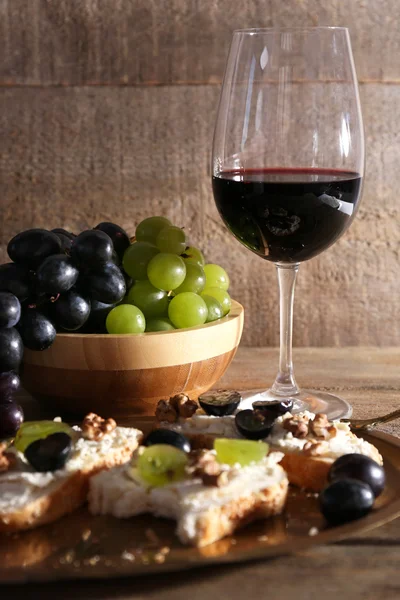 Hermoso bodegón con vino, queso y uva madura sobre fondo de madera —  Fotos de Stock