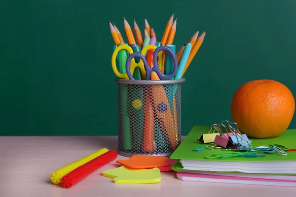 Material escolar na mesa a bordo de fundo — Fotografia de Stock