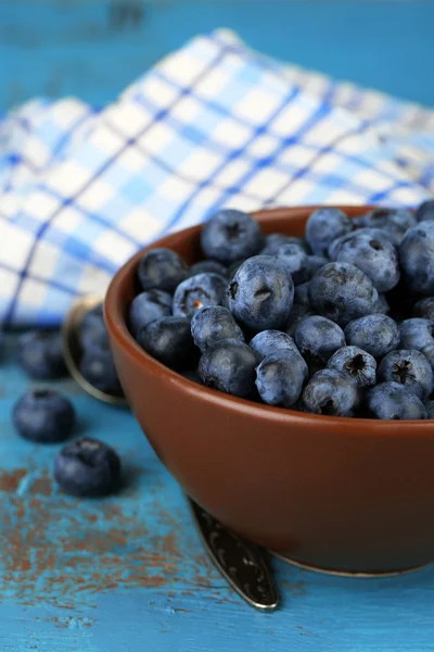 Tasty ripe blueberries in bowl, on wooden table — Stock Photo, Image