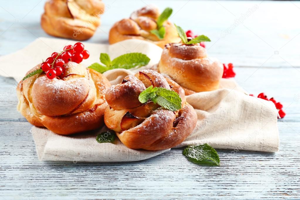 Tasty buns with berries on table close-up