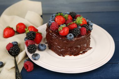 ahşap masa üzerinde farklı meyveleri lezzetli çikolatalı kek