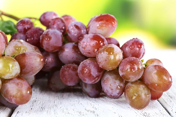 Bando de uvas maduras em mesa de madeira sobre fundo natural — Fotografia de Stock