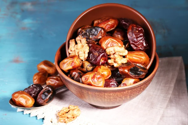 Tasty dates fruits in bowls, on blue wooden background — Stock Photo, Image