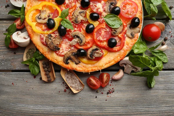 Läcker pizza serveras på träbord — Stockfoto
