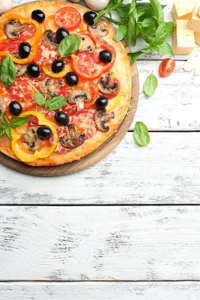 Läcker pizza serveras på träbord — Stockfoto