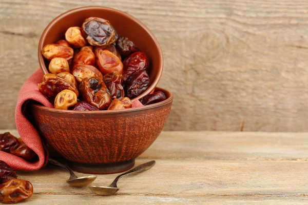 Tasty dates fruits in bowls, on wooden background — Stock Photo, Image