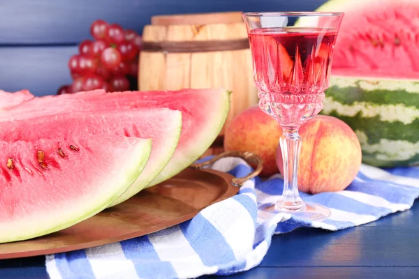 Skład dojrzały arbuz, owoce, różowe wino w szklane i drewniane beczki na kolor drewniane tła — Zdjęcie stockowe