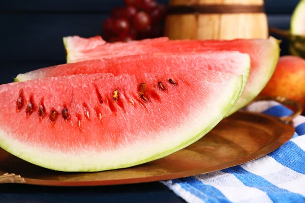 Composition of ripe watermelon, fruits, pink wine in glass and wooden barrel on color wooden background — Stock Photo, Image