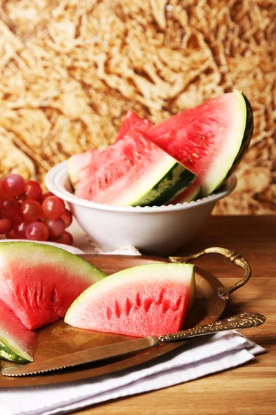 Composizione di anguria matura, frutta sul tavolo di legno a colori, sullo sfondo della parete a colori — Foto Stock