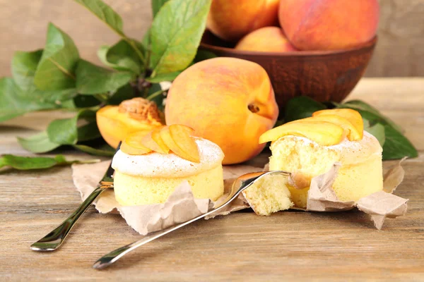 Leckere Mini-Kuchen mit frischem Pfirsich, auf Holztisch — Stockfoto