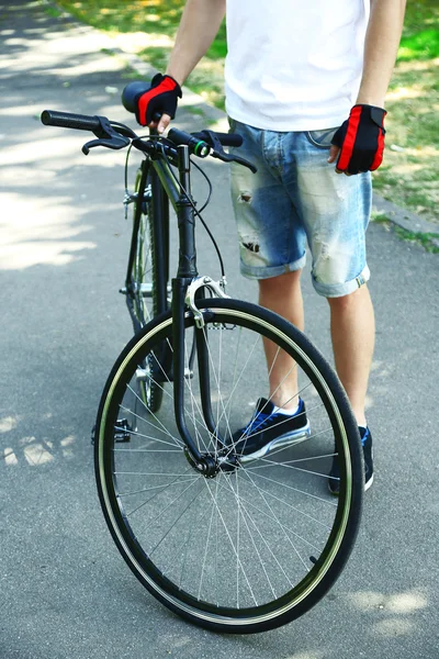 Young man riding bike in city park — Stock Photo, Image