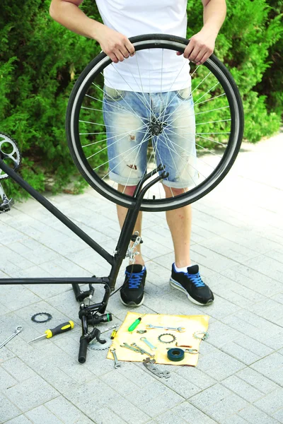 Человек чинит свой велосипед, крупным планом — стоковое фото