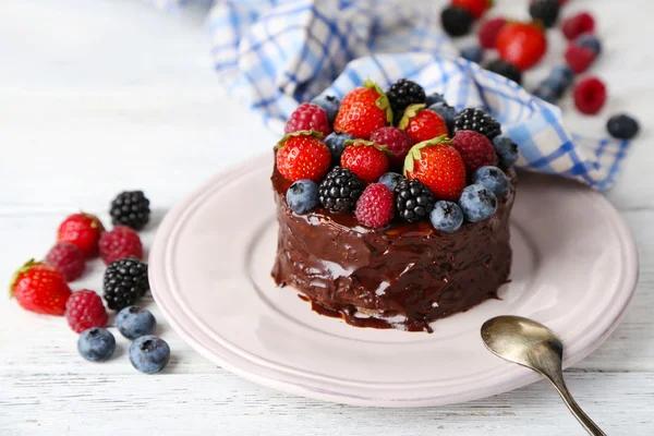 Smaczne ciasto czekoladowe z różnych owoców, na drewnianym stole — Zdjęcie stockowe