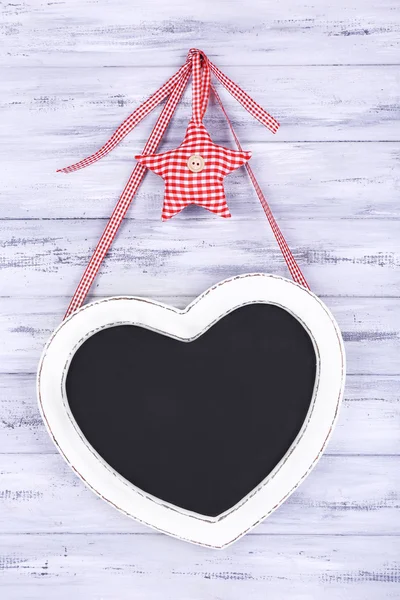 Heart shaped chalkboard on wooden background — Stock Photo, Image