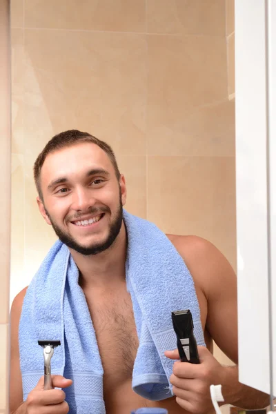 Молодий чоловік голить свою бороду у ванній — стокове фото