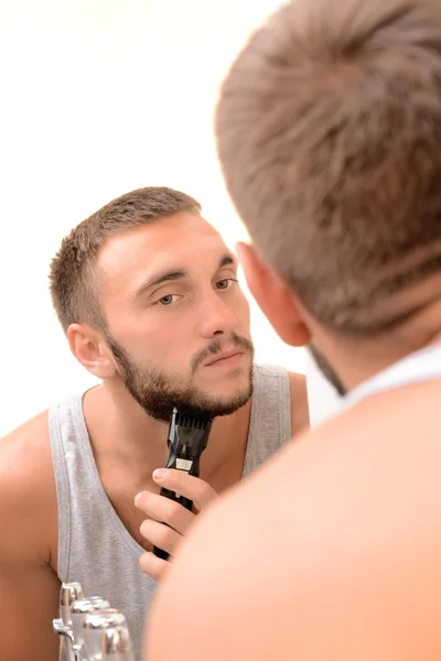 Молодой человек сбрил бороду в ванной — стоковое фото