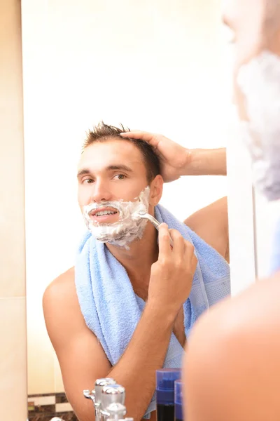 Jongeman scheren zijn baard in badkamer — Stockfoto