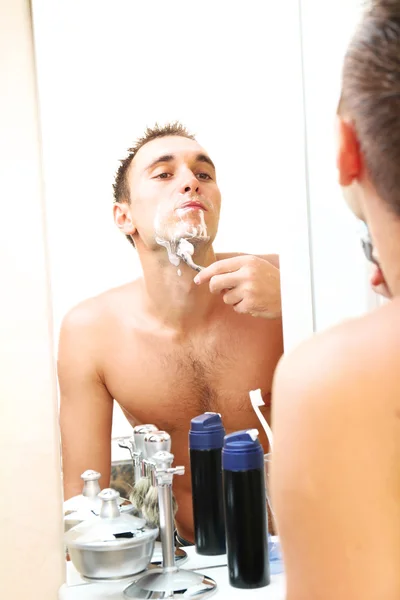 Young man shaving his beard in bathroom — Stock Photo, Image