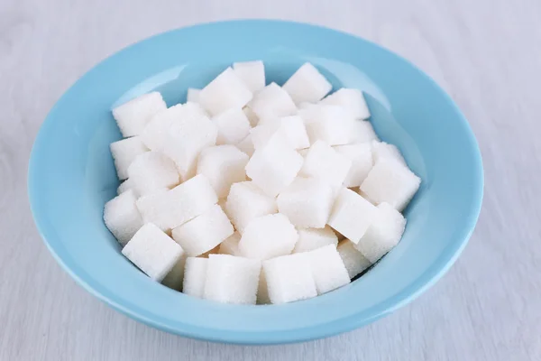 Refined sugar in color bowl on wooden background — Stock Photo, Image