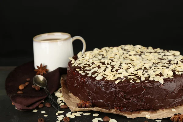 アーモンド、暗い背景上の木製のテーブルの上においしいチョコレート ケーキ — ストック写真